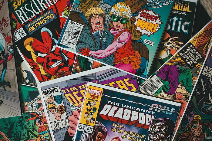 Das Foto zeigt etliche Comic-Hefte, die übereinander liegen.