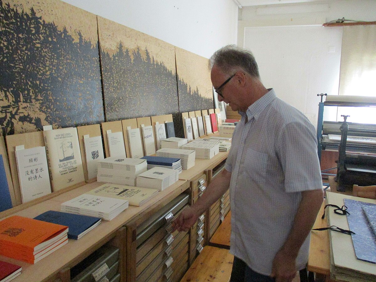 Die Werkstatt der Edition Thanhäuser mit Stifters Wald als Holzschnitt an der Wand, lieferbaren Büchern und Setzkästen