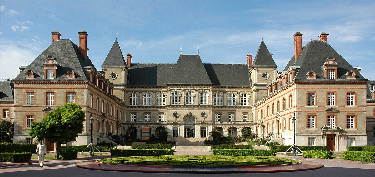 Das Foto zeigt das Gebäude in dem die Zentralbibliothek der Cité Internationale Universitaire untergebracht ist. Die sogenannte Maison Internationale ist ein altes Gebäude mit zwei nach vorne hervorragenden Seitenflügeln.  