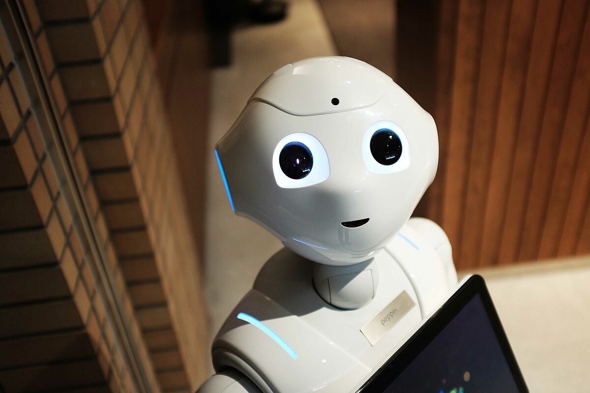 Das Foto zeigt den humanoiden Roboter Pepper, der in die Kamera schaut.
