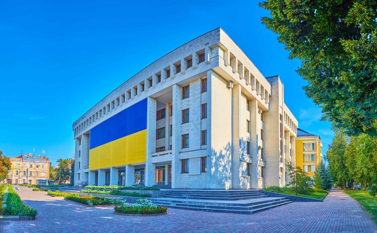 An der Fassade der Nationalbibliothek Kotliarevsky in Poltawa in der Ukraine ist eine riesige ukrainische Flagge zu sehen.