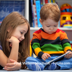 Girl with her little brother fun using a digital tablet computer